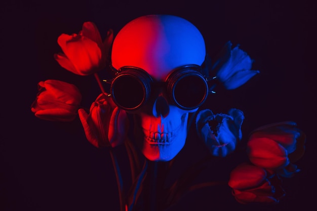 Human skull in steampunk glasses in tulip flowers with red and blue neon light