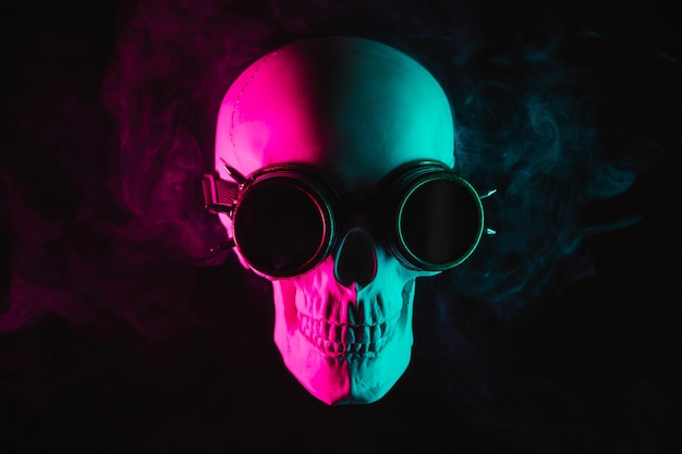 Human skull in steampunk glasses with pink green neon light with smoke