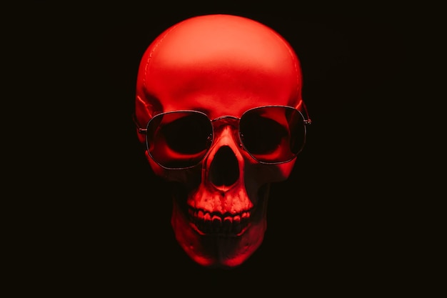 Human skull wearing sunglasses in red light