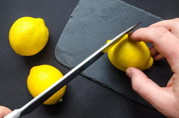 Photo human slicing yellow lemon