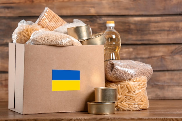 우크라이나 난민을 위한 인도적 지원 나무 테이블에 음식이 있는 기부 상자