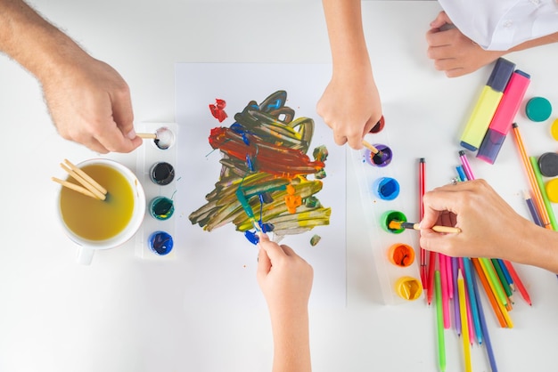 Humans hand is drawing with colorful pencils Top view