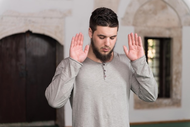 Foto l'umile uomo musulmano sta pregando nella moschea