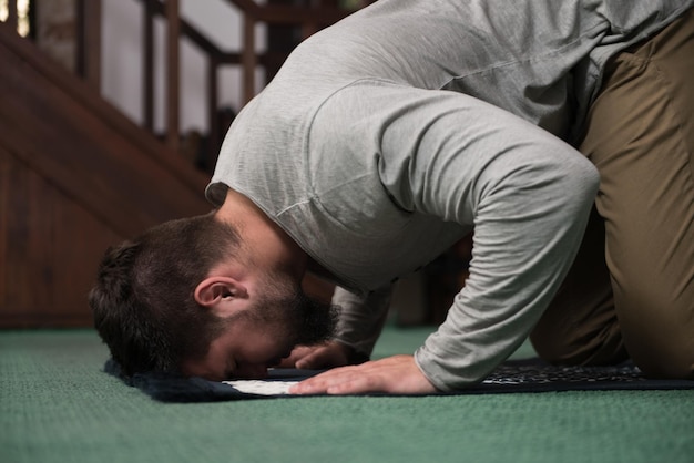 Photo humble muslim man is praying in the mosque