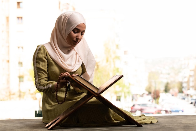 Humble muslim woman is praying with quran