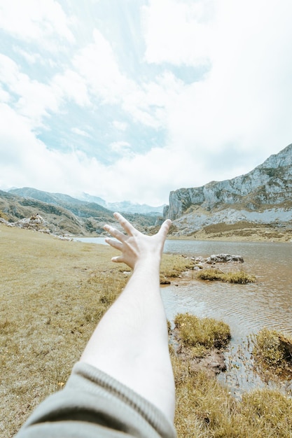 Humeurig behang van een onscherpe hand voor een kleurrijk landschap van de bergen van Asturië tijdens een zonnige dag, Covadonga-meren, vredig scenario, besneeuwde bergen, kopieerruimte