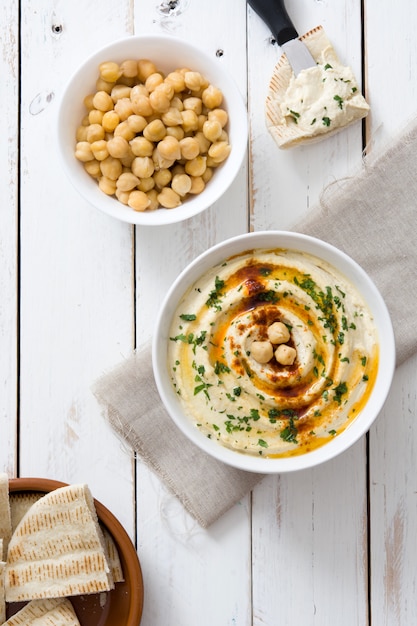 Hummus in kom op een rustieke witte houten tafel