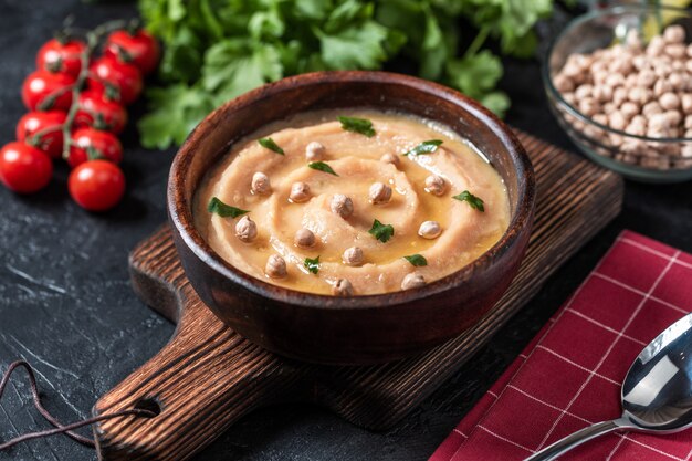 Hummus into a brown wooden plate. 