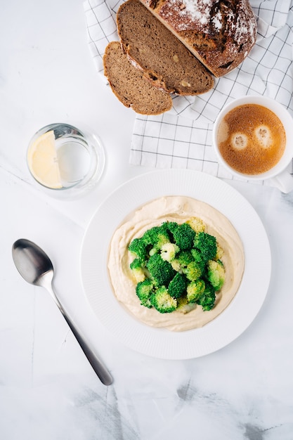 Hummus met broccoli, brood en koffie met water. Ontbijt. Midden-Oosters gerecht. Bovenaanzicht