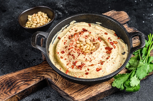 Hummus paste with chickpea and parsley in a bowl.