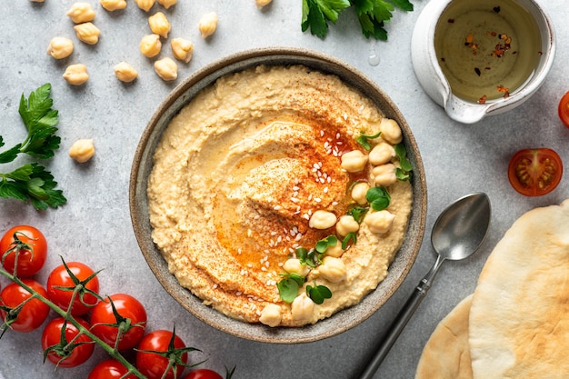 Hummus and pita on a light table, top view