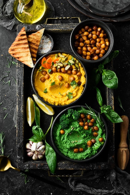 Hummus spicy hummus of green peas and chickpeas with olive oil in a bowl on a concrete background