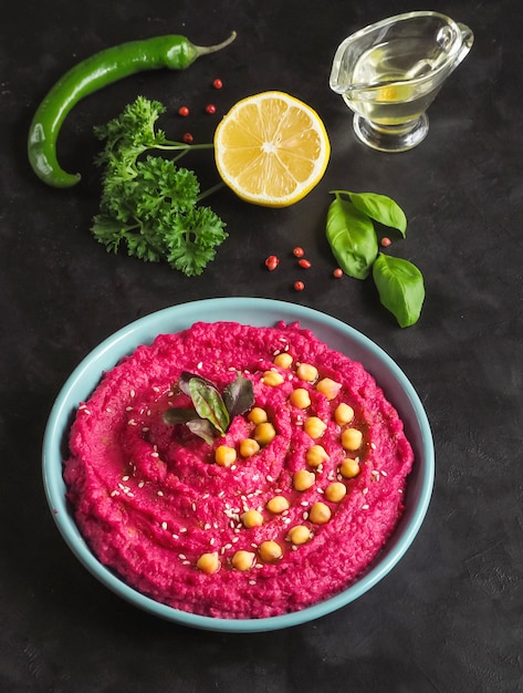 Hummus with beetroot on a black kitchen table