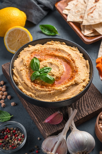 Hummus with olive oil and paprika on the background of ingredients