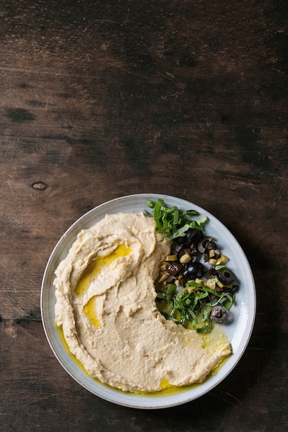 Photo hummus with olives and herbs