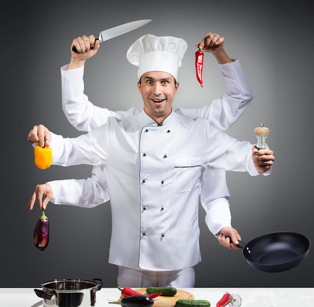 Foto humoristisch portret van een chef-kok met vele handen