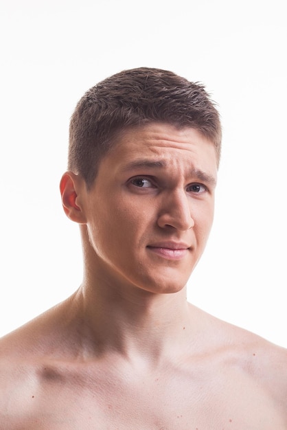 Humorous emotional portrait of grimacing young man