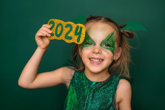 드래곤 모양의 얼굴 패턴을 가진 유머러스 한 소녀는 2024 숫자로 눈을 고 있습니다.