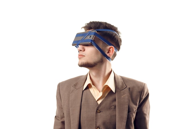 A humorous photo of modern technologies. Young guy with a phone attached to the head using a tape. Virtual reality gadget. Cut out on white