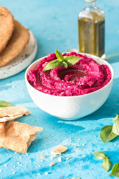 Humus Bowl Red beetroot hummus with fresh vegetables olive oil on table