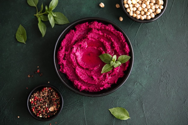 Humus schaal. Rode bietenhummus met verse groenten, olijfolie op tafel