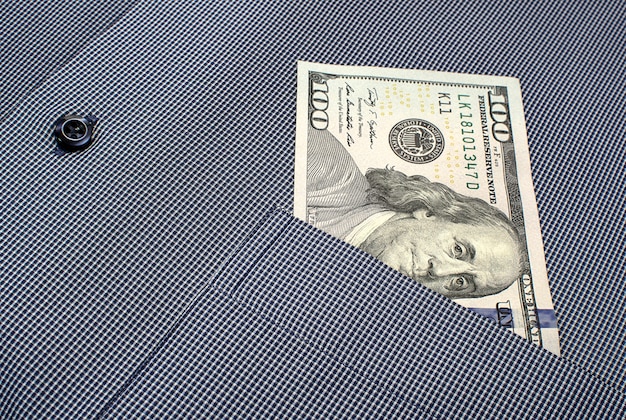 Photo hundred dollar banknote in the pocket of a checkered shirt