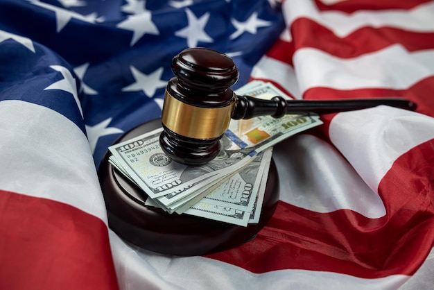 Hundred dollar bills and a judge's gavel placed on an American flag