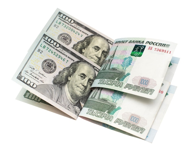Сто долларов американских банкнот и тысяча рублей российских, изолированные на белом фоне. Финансы, международная политика