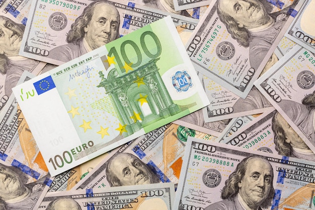 Hundred euro bank note on american hundred dollars finance background.