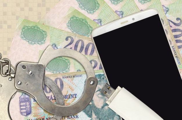 Hungarian forint bills and smartphone with police handcuffs