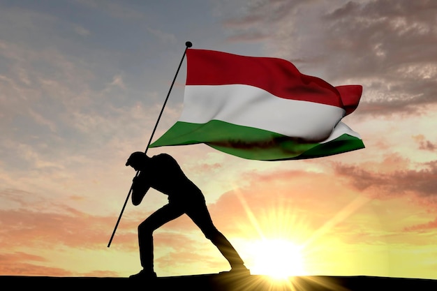 Hungary flag being pushed into the ground by a male silhouette 3D Rendering