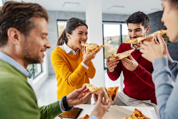 Hungry businesspeople having pizza for lunch at the office