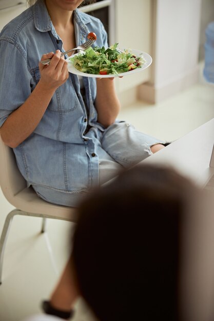 Foto donna affamata che mangia insalata