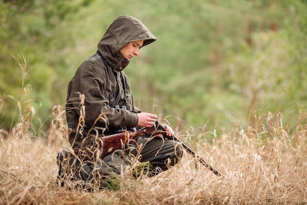 Hunter laadt geweer in een winterbos Bushcraft jacht en mensenconcept