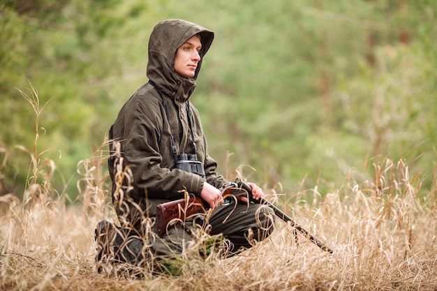 Hunter laadt geweer in een winterbos Bushcraft jacht en mensenconcept