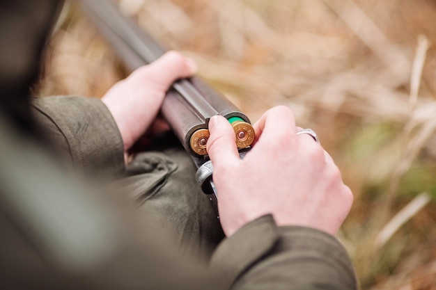 Hunter laadt geweer in een winterbos Bushcraft jacht en mensenconcept