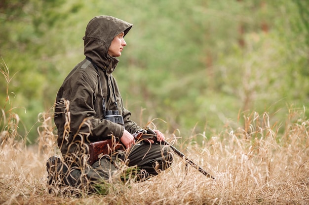 Hunter loading rifle in a winter forest Bushcraft hunting and people concept