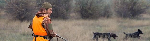 Photo hunter man in camouflage with a gun during the hunt in search of wild birds or game