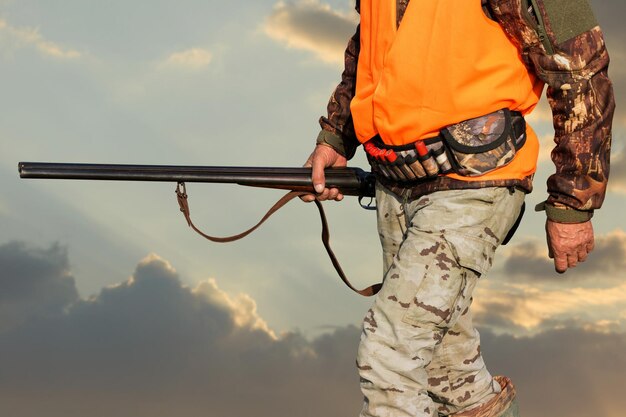 Hunter man in camouflage with a gun during the hunt in search of wild birds or game Autumn hunting season