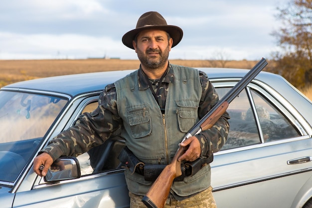 Hunter man in camouflage with a gun during the hunt in search of wild birds or game