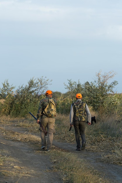 Hunter man in camouflage with a gun during the hunt in search of wild birds or game