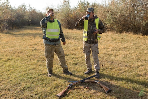 Hunter man in camouflage with a gun during the hunt in search of wild birds or game