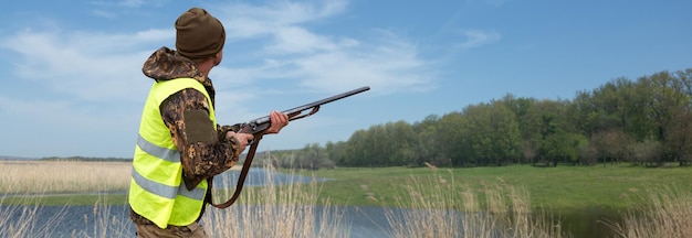 野鳥やゲームを探して狩り中に銃でカモフラージュのハンター男