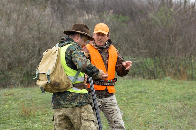 Hunter man in camouflage with a gun during the hunt in search of wild birds or game