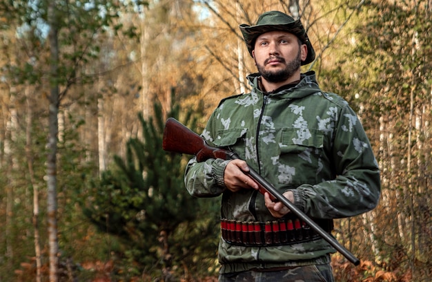 Hunter man in camouflage with a gun during the hunt