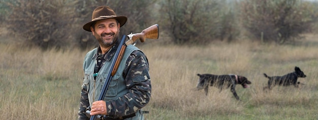 Фото Человек-охотник в камуфляже с ружьем во время охоты в поисках диких птиц или дичи