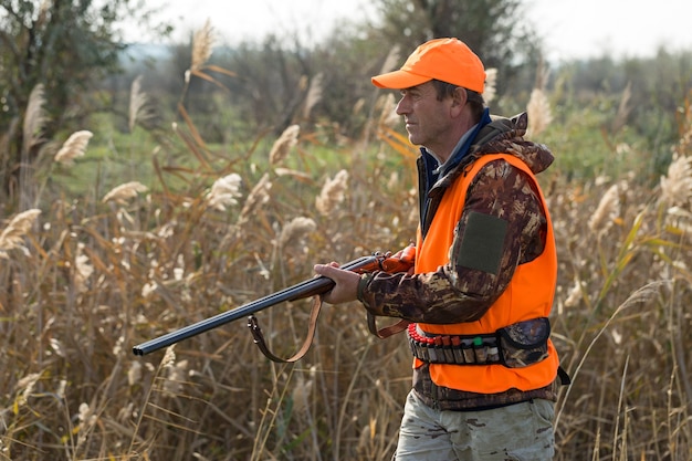 사진 야생 조류 또는 게임을 찾아 사냥하는 동안 총으로 위장에 헌터 남자
