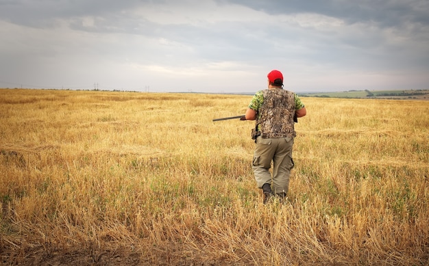 Hunter moving with shotgun looking for prey.