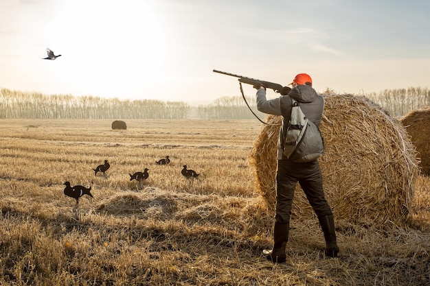 Hunter shooting to the flying bird