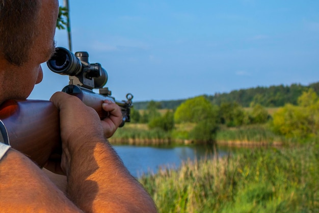 Photo hunter shooting with rifle point and shoot